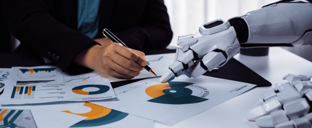 Robot hand helping human hand with business